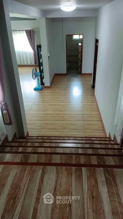 Spacious interior with wooden flooring and natural light, perfect for modern living.
