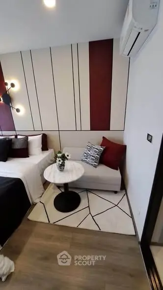 Stylish modern bedroom with chic decor and cozy seating area, perfect for relaxation.