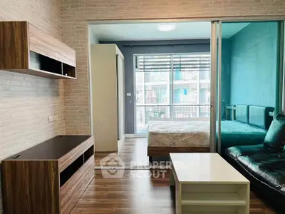 Modern studio apartment with glass partition, stylish furniture, and natural light.