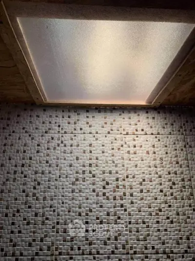 Modern bathroom ceiling with mosaic tile design and recessed lighting.