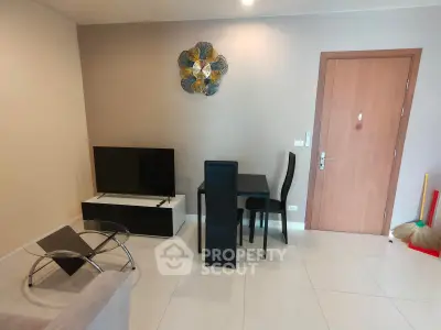Modern living room with sleek furniture and wall art, featuring a TV and dining area.