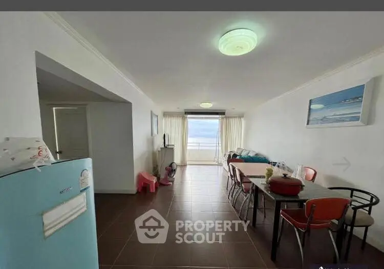 Spacious living room with dining area and ocean view, featuring modern decor and ample natural light.