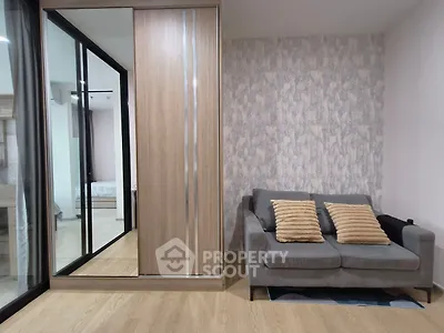 Modern living room with stylish sofa and mirrored wardrobe