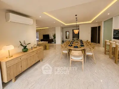 Spacious modern living and dining area with elegant lighting and stylish furniture.
