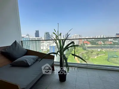 Stunning balcony with panoramic city view and cozy seating area.