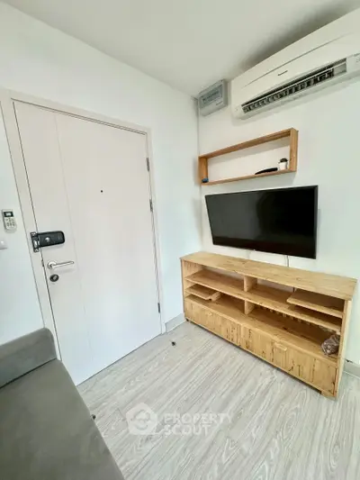 Modern living room with sleek TV setup and air conditioning, perfect for cozy urban living.