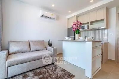 Modern living room with cozy sofa and stylish kitchen island in open layout apartment.
