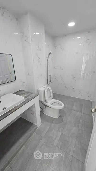 Modern bathroom with sleek marble tiles and contemporary fixtures.