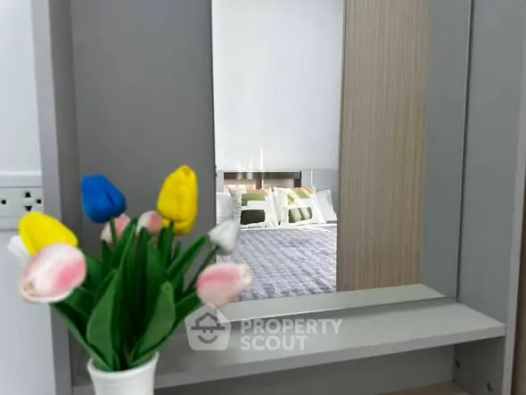 Stylish bedroom with modern decor and colorful flower arrangement, reflecting a cozy and inviting atmosphere.