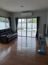 Spacious living room with large windows and modern furnishings, perfect for relaxation and entertainment.