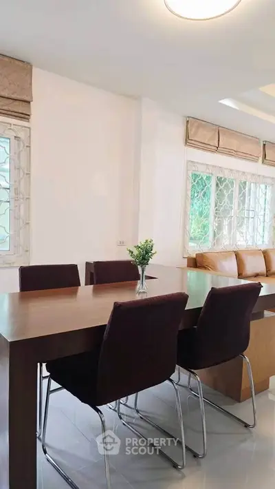 Modern dining area with elegant table and chairs, featuring natural light and stylish decor.