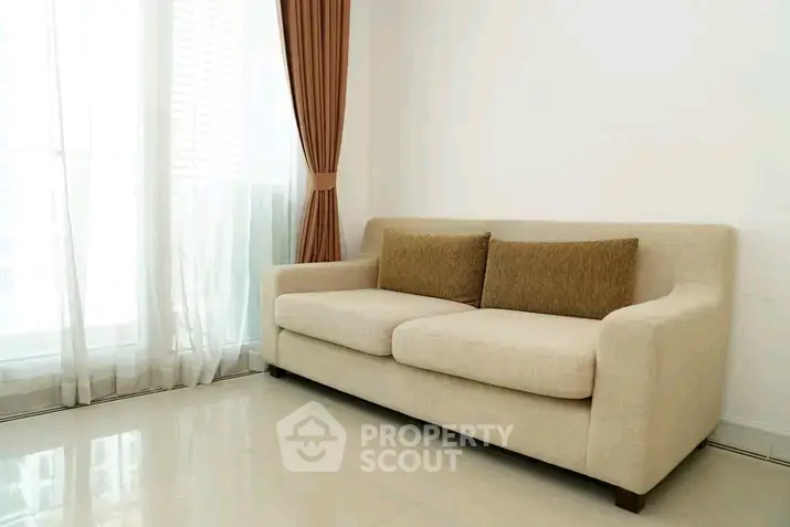 Modern living room with elegant beige sofa and floor-to-ceiling windows