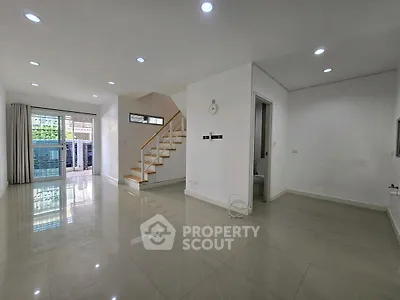 Spacious modern living room with staircase and large windows
