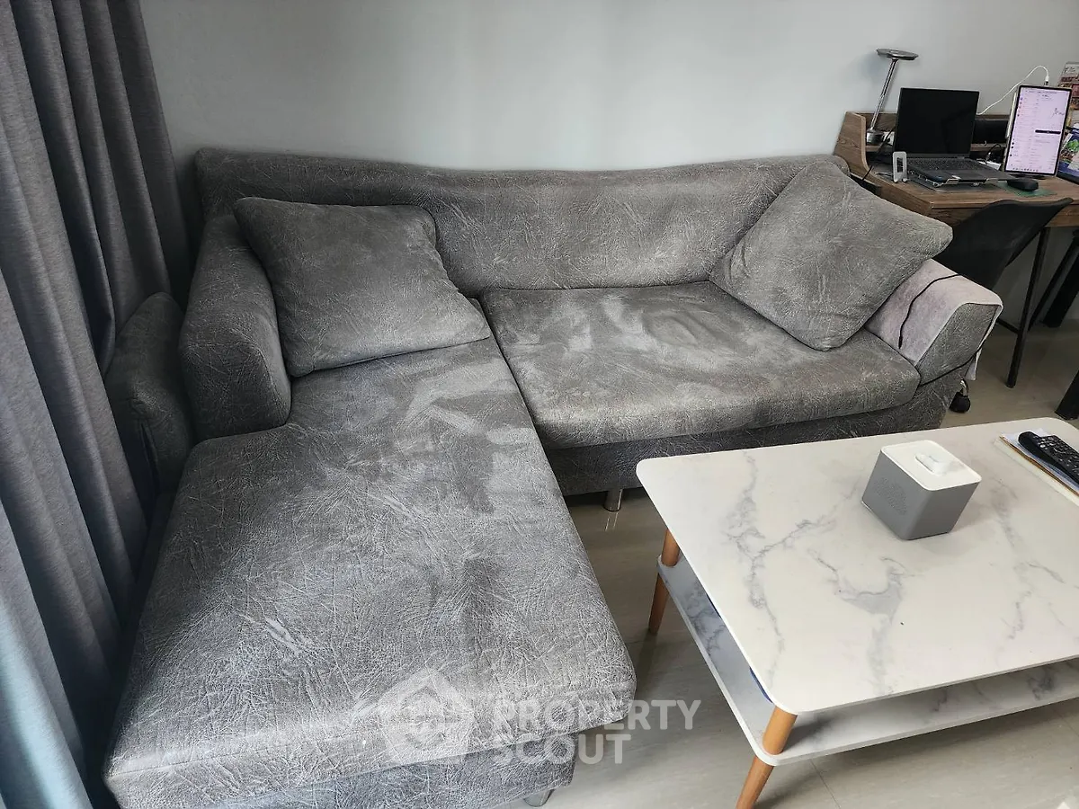 Modern living room with stylish gray sofa and marble coffee table, perfect for relaxation and entertainment.