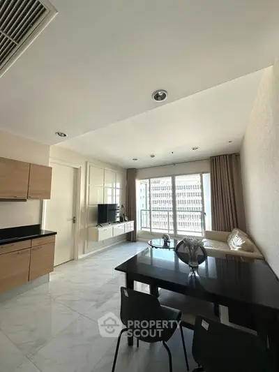 Modern living room with sleek furniture and large windows offering city views.