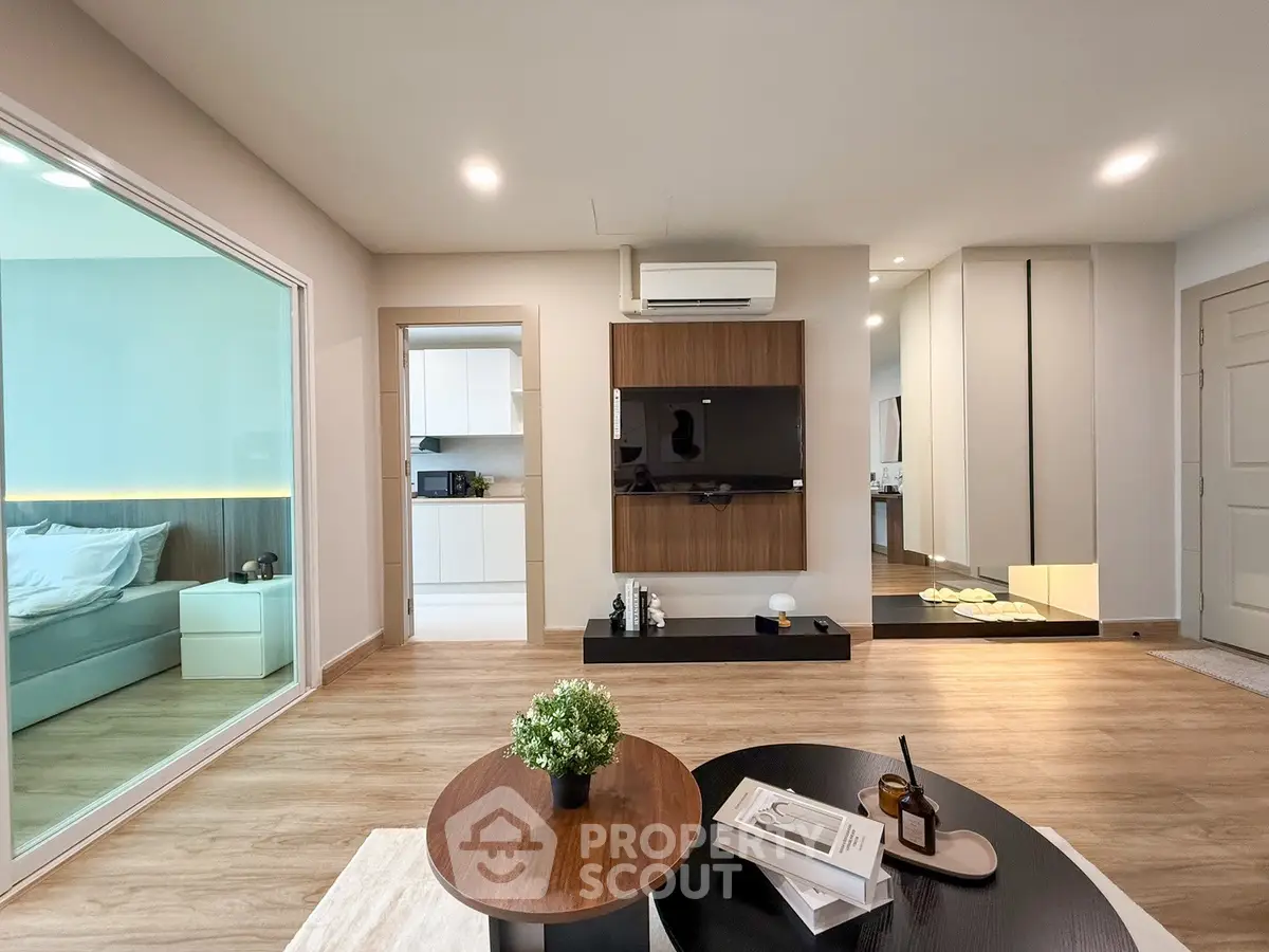 Modern living room with sleek design and open layout, featuring a cozy bedroom view.