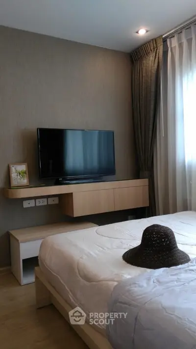Modern bedroom with sleek TV setup and cozy decor