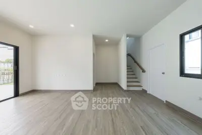 Spacious modern living room with wooden flooring and staircase