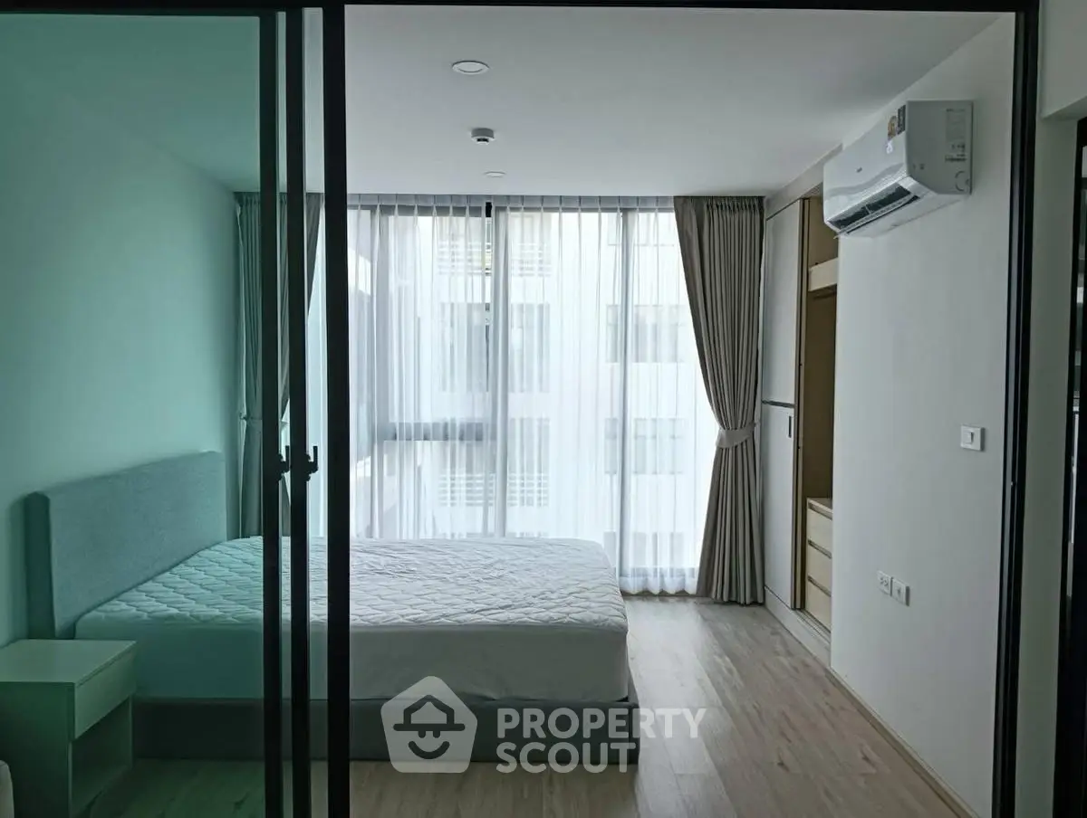 Modern bedroom with large windows and natural light in a stylish apartment.