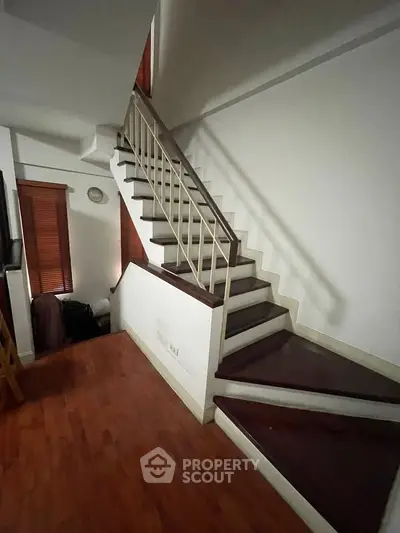 Stylish interior staircase with wooden steps and modern railing in a contemporary home.