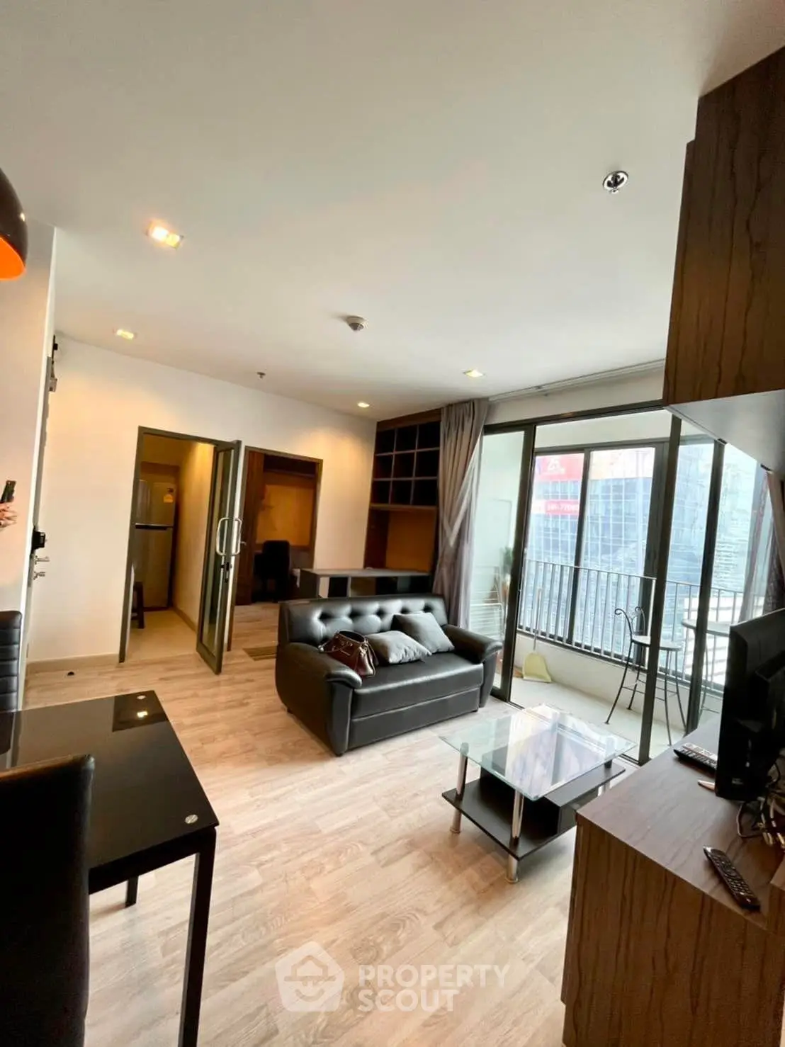 Spacious modern living room with large windows and stylish furnishings in a high-rise apartment.