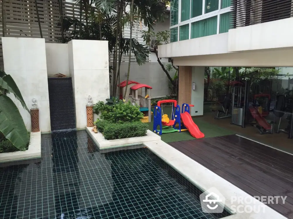 Luxurious condo with pool and children's play area in a lush garden setting.