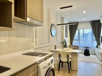Modern open-layout kitchen and living room with stylish decor and natural light.