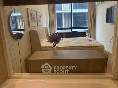 Modern bedroom with large window and stylish decor, featuring a comfortable bed and elegant furnishings.