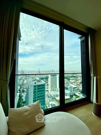 Stunning high-rise apartment with panoramic city view from large window, offering modern urban living.