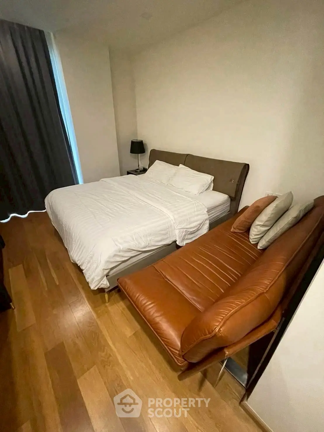 Cozy bedroom with wooden flooring and stylish leather seating