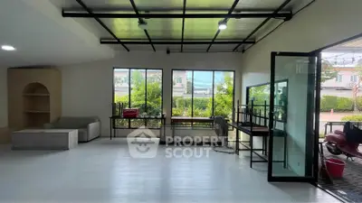 Spacious modern living room with large windows and sleek design, perfect for natural light lovers.