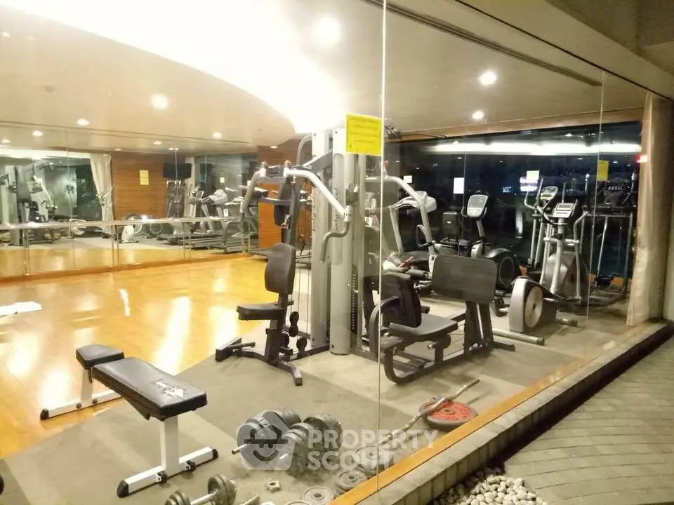 Spacious modern gym with state-of-the-art equipment in luxury residential building.