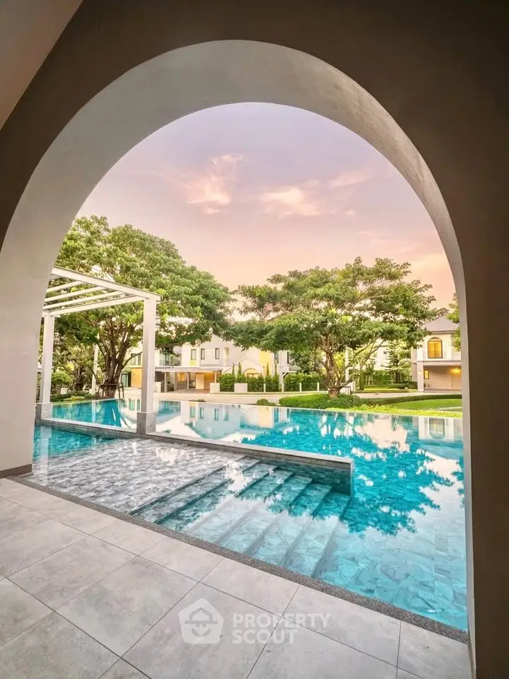 Luxurious poolside view with serene surroundings and elegant architecture at sunset.