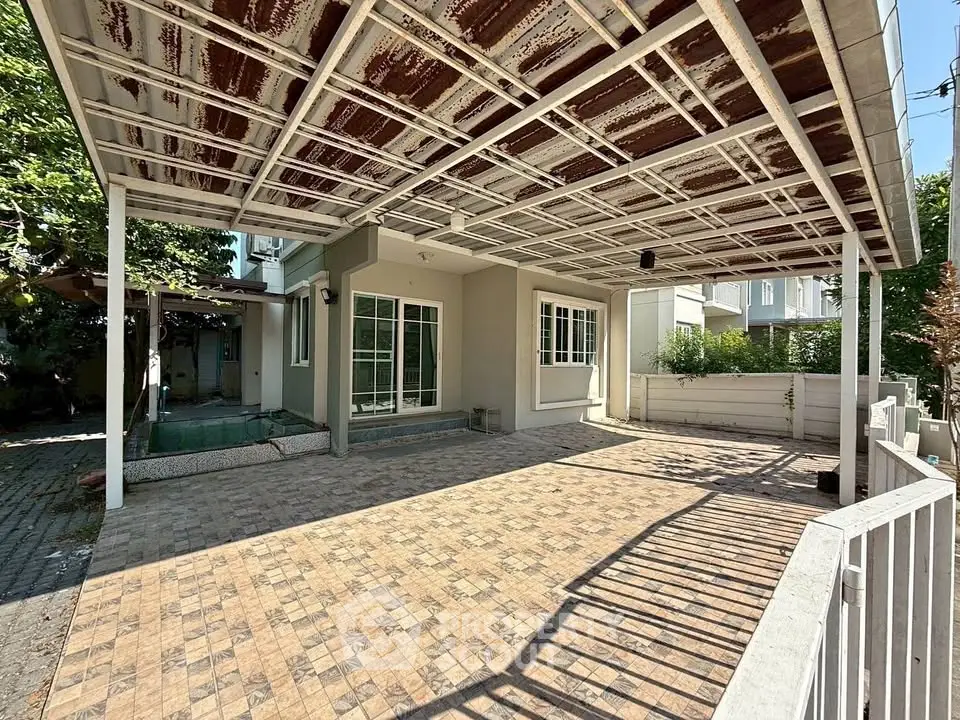 Spacious outdoor patio with covered roof and tiled flooring, perfect for entertaining and relaxation.