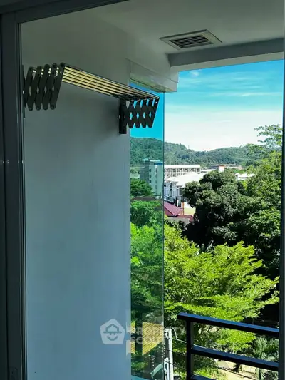 Stunning balcony view with lush greenery and mountains, perfect for relaxation and enjoying nature.