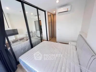 Modern bedroom with glass partition and air conditioning in stylish apartment.