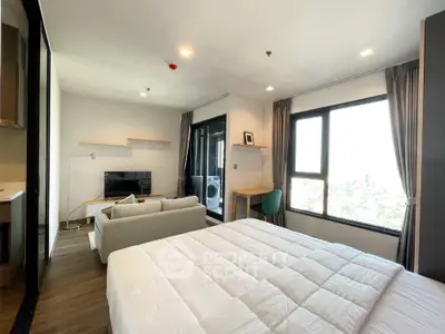Modern studio apartment with large windows and cozy furnishings