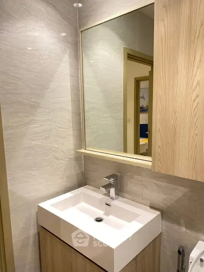 Modern bathroom with sleek vanity and large mirror in stylish apartment