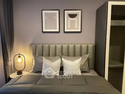 Modern bedroom with stylish decor and cozy lighting, featuring elegant artwork above the bed.
