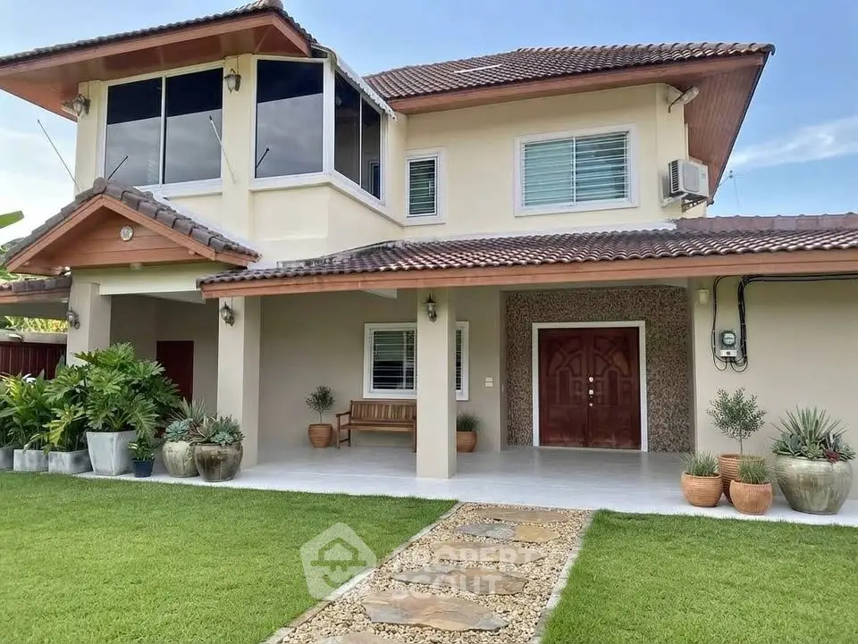 Charming two-story house with lush garden and elegant entrance in serene neighborhood.