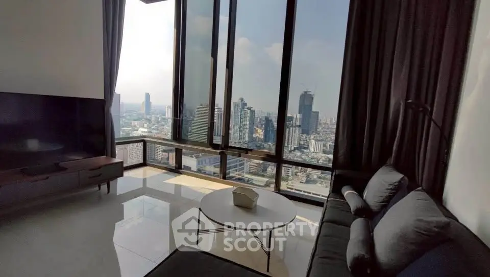 Luxurious high-rise living room with stunning city skyline view through floor-to-ceiling windows.