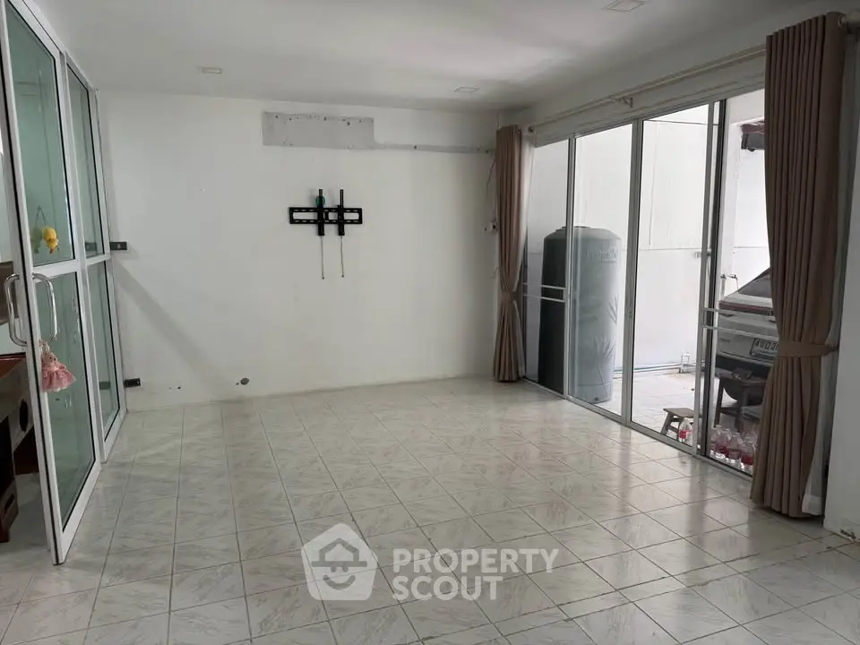 Spacious unfurnished room with tiled floor and large windows, ideal for customization.