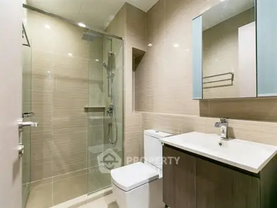 Modern bathroom with glass shower and sleek vanity in luxury apartment.