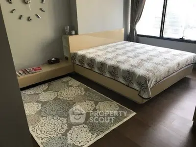 Spacious bedroom with modern decor and large window offering natural light.