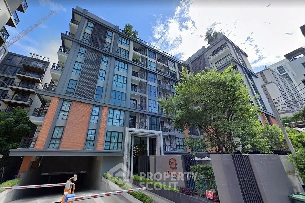 Modern urban apartment building with lush greenery and stylish facade in vibrant city setting.