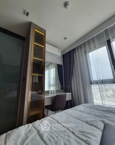 Modern bedroom with city view, featuring sleek furniture and large windows for natural light.