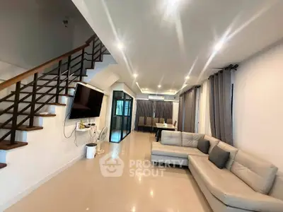 Spacious modern living room with elegant staircase and cozy sectional sofa