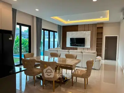 Luxurious living room with elegant dining area and pool view, featuring modern decor and ample natural light.