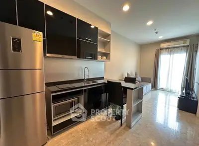 Modern open-layout kitchen with sleek appliances and cozy living area in a stylish apartment.