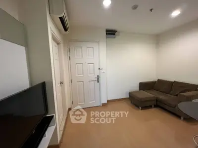 Cozy living room with brown sofa and flat-screen TV, perfect for relaxation.